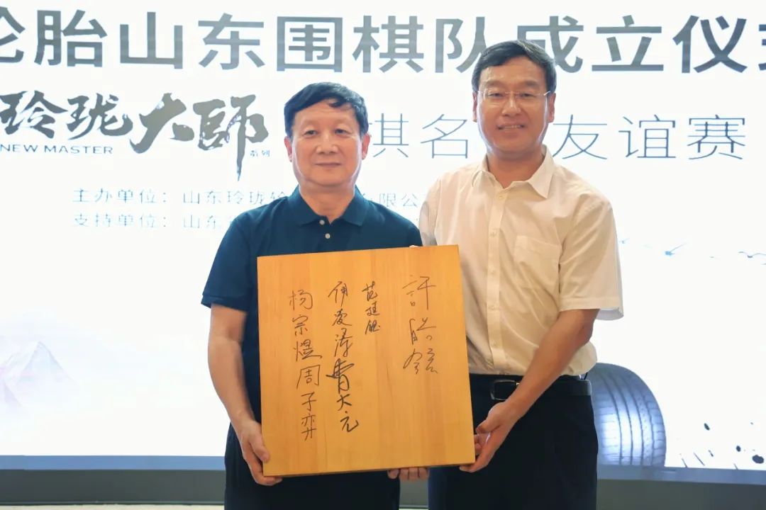 玲珑轮胎山东围棋队主教练 曹大元(左)向玲珑轮胎董事长,总裁 王锋(右